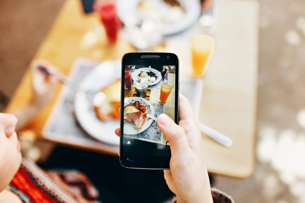 A lady taking content about food for a restaurant. An example of influencer campaigns in Ghana